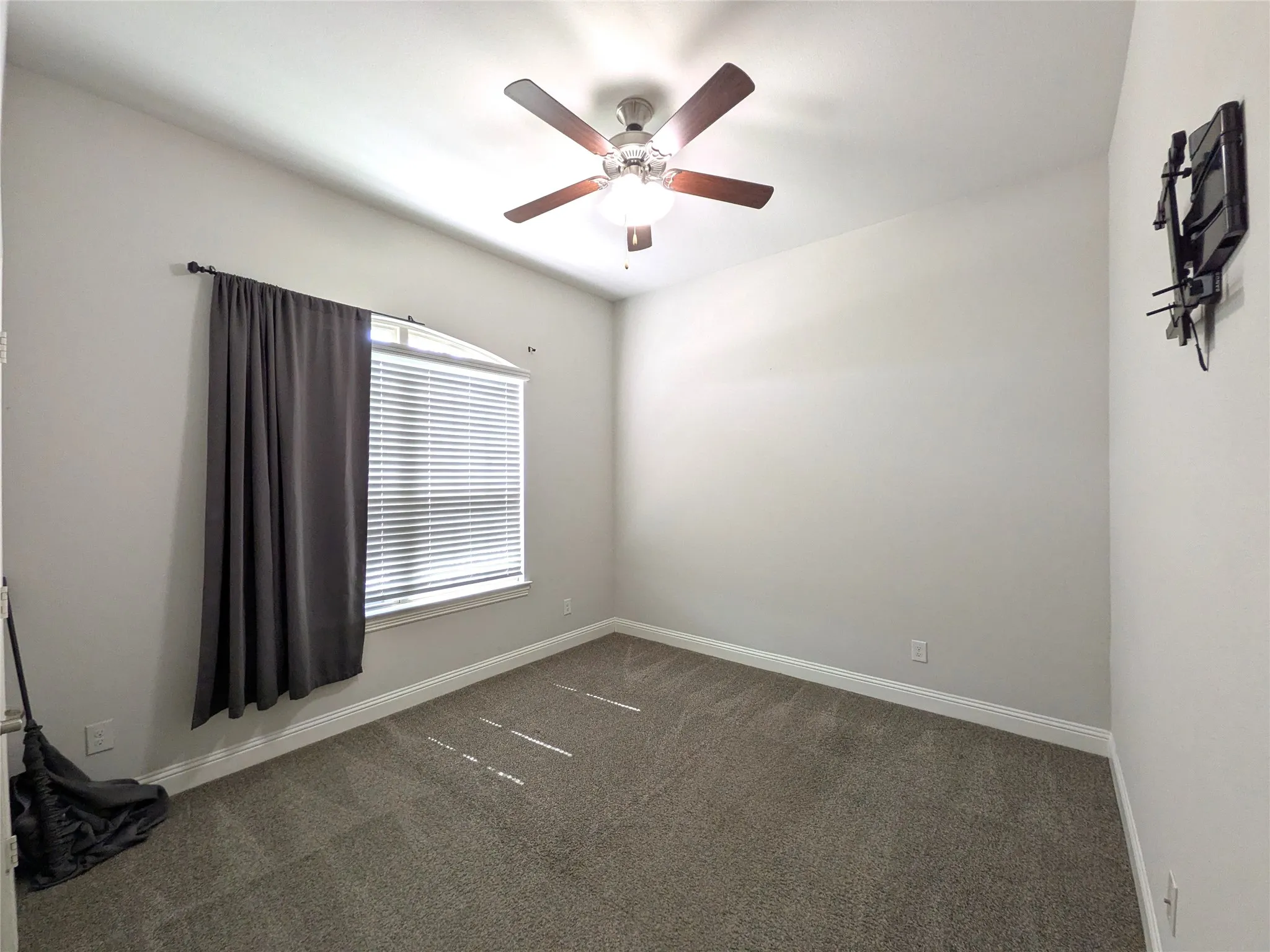 Carpeted flooring, window with blinds, ceiling fan with integrated lighting, and neutral wall tones