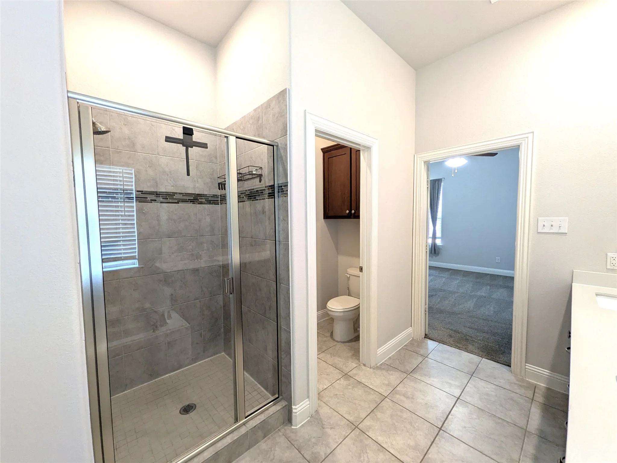 Glass-enclosed shower with tile surround and built-in bench