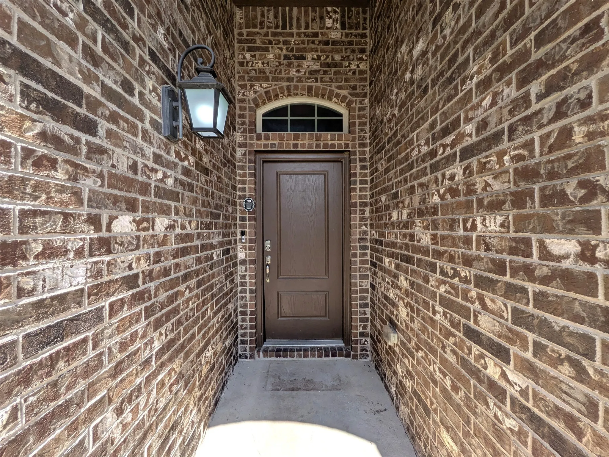 Brick exterior with an arched transom window above the entry door