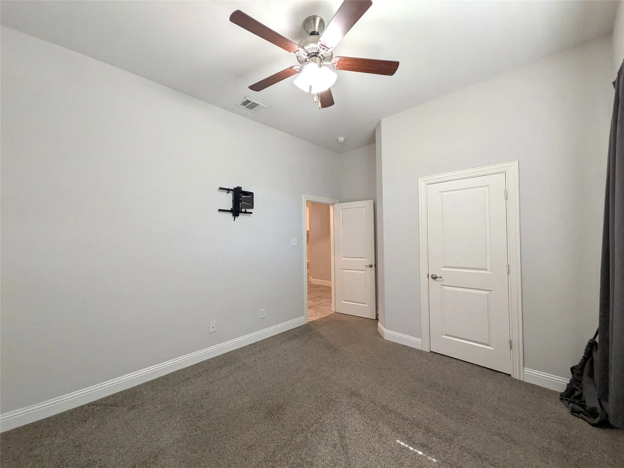 Carpeted room with high ceilings, recessed lighting, and a ceiling fan
