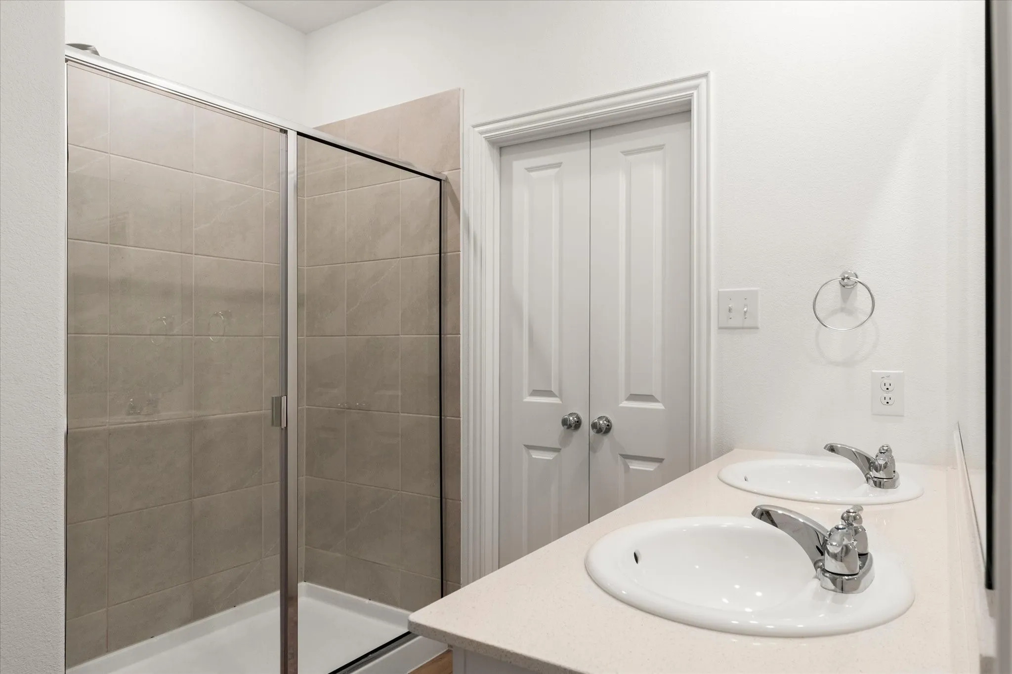 Dual vanity with integrated sinks, chrome fixtures, and a neutral countertop
