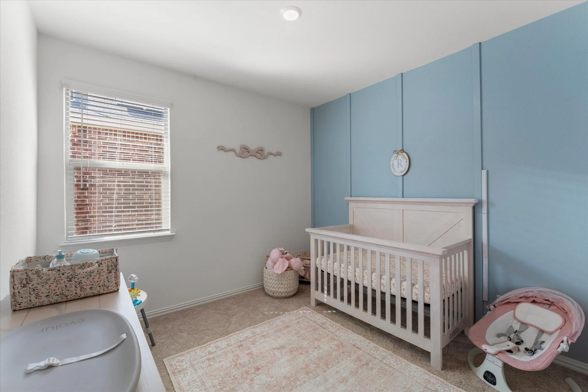 Wall-to-wall carpeting with light-toned walls and an accent wall featuring vertical paneling
