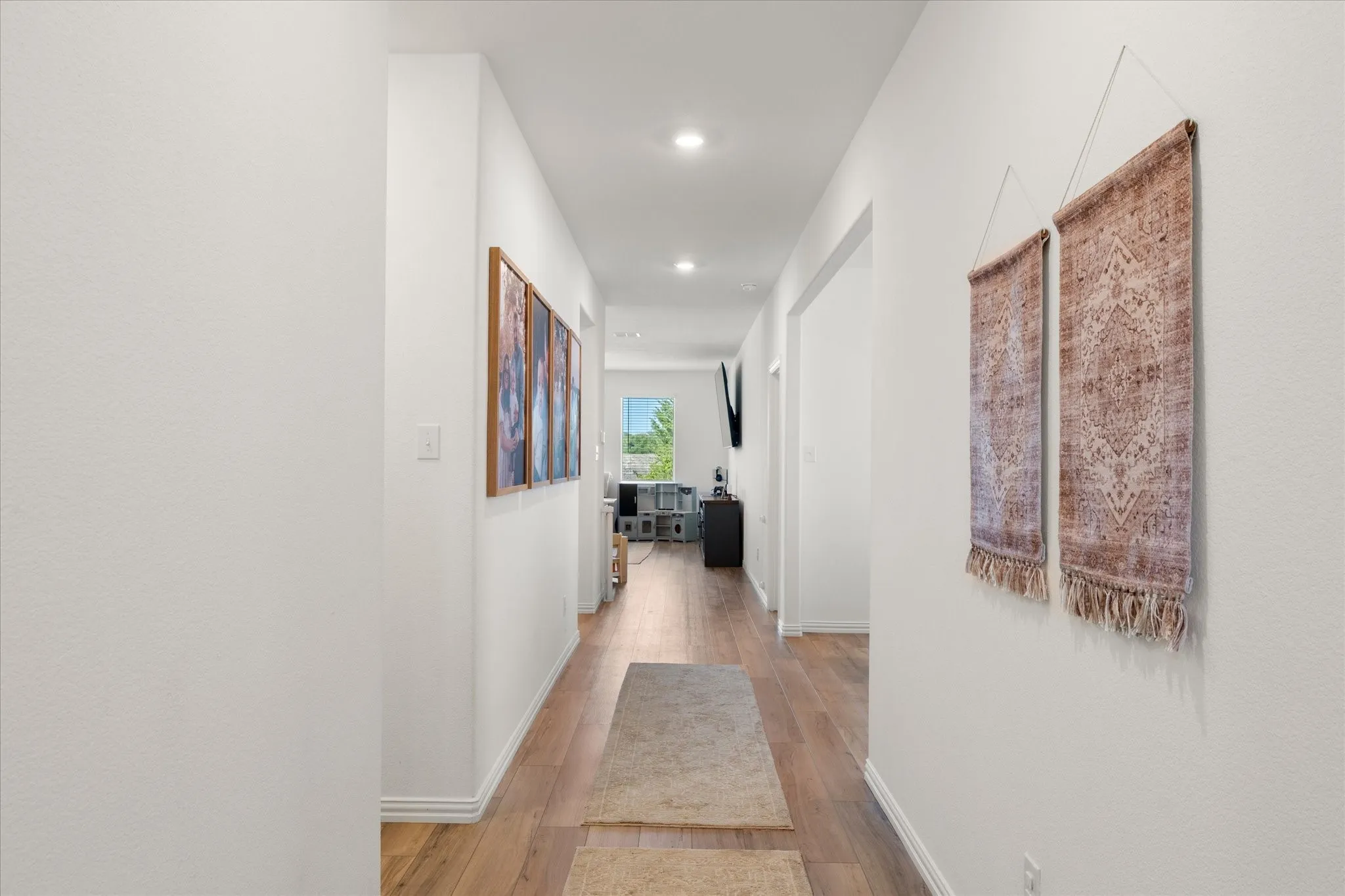 Recessed ceiling lighting, wood-finish flooring, white walls, and bright natural light