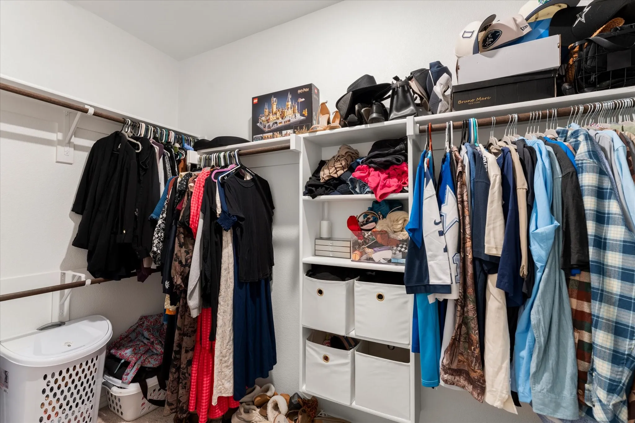 Walk-in closet with built-in shelving, multiple hanging rods, and white walls