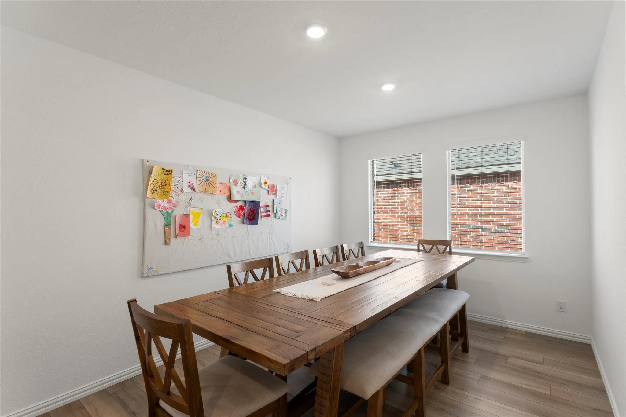 Wood-finish flooring with white walls and recessed lighting