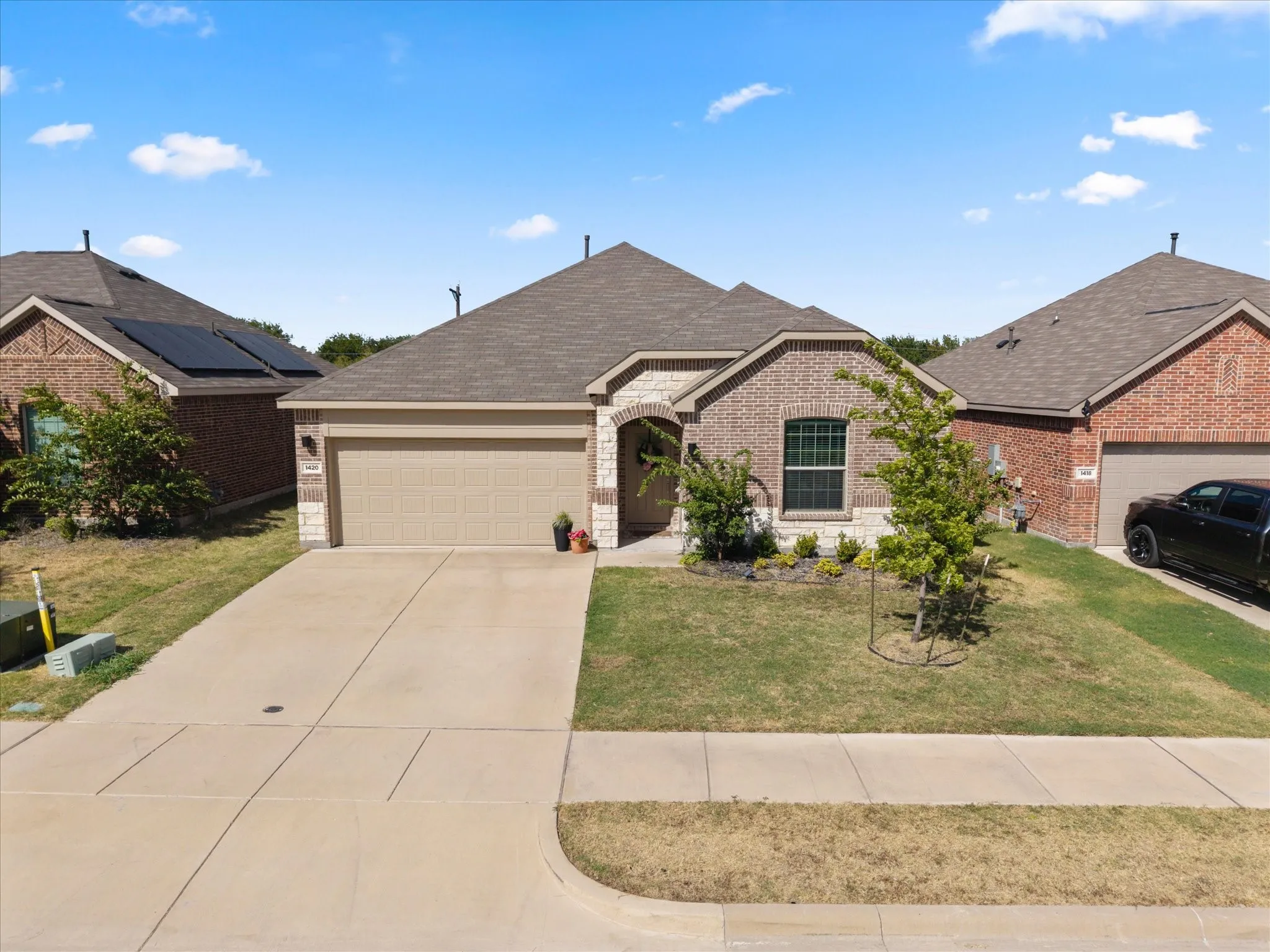 Brick exterior with stone accents, covered entry, and an attached two-car garage