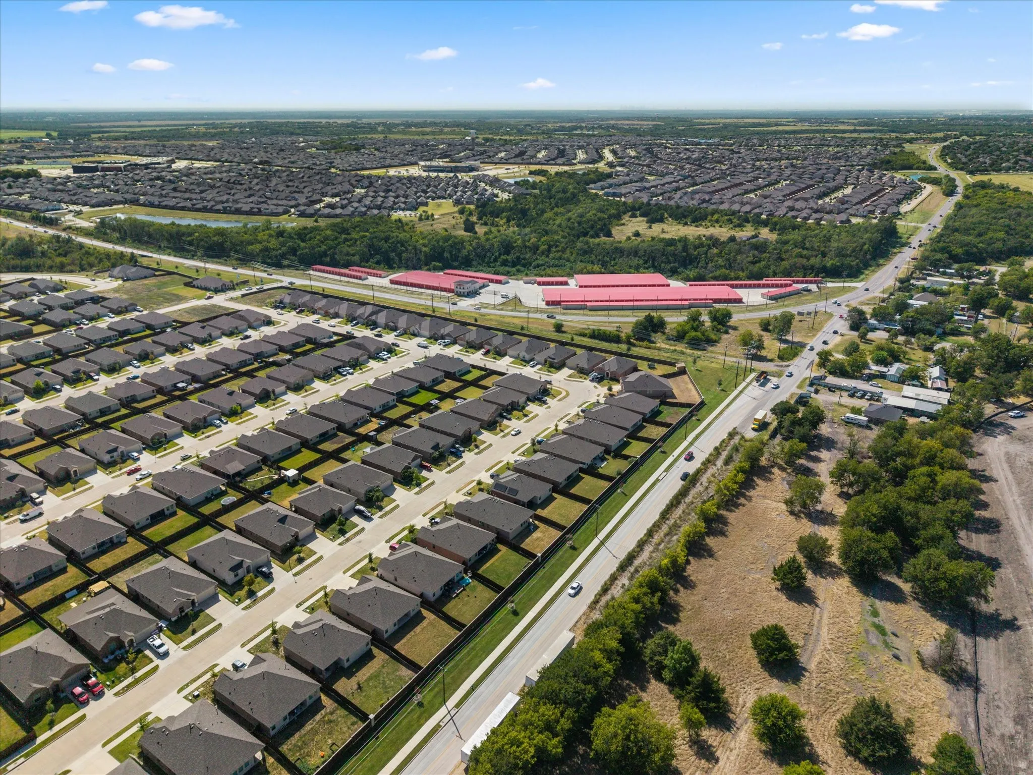 Residential neighborhood featuring single-story homes with dark roofs and light-colored exteriors