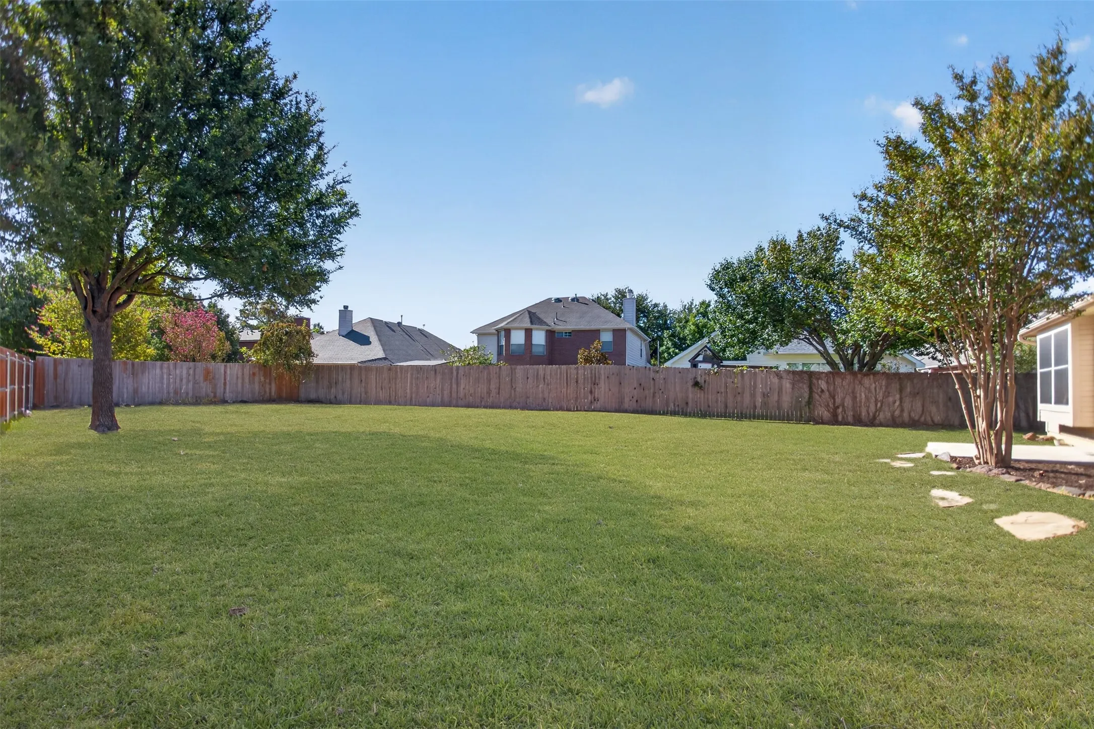 Large backyard grass with some trees
