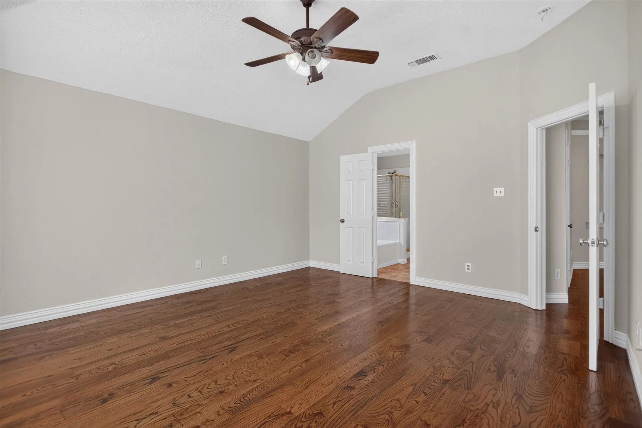 Gorgeous flooring flows into the primary suite with high ceilings