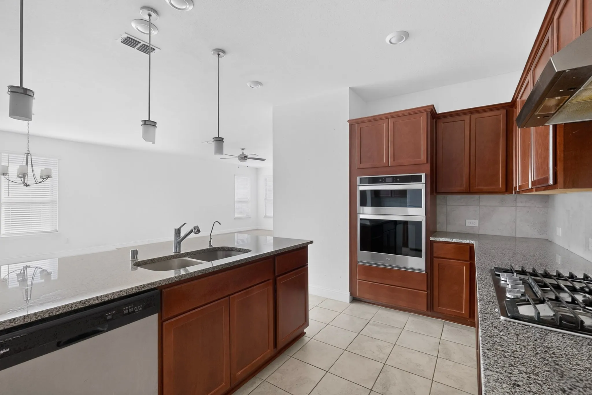 Kitchen featuring wood cabinetry, stainless steel appliances, a double basin sink, and a gas cooktop