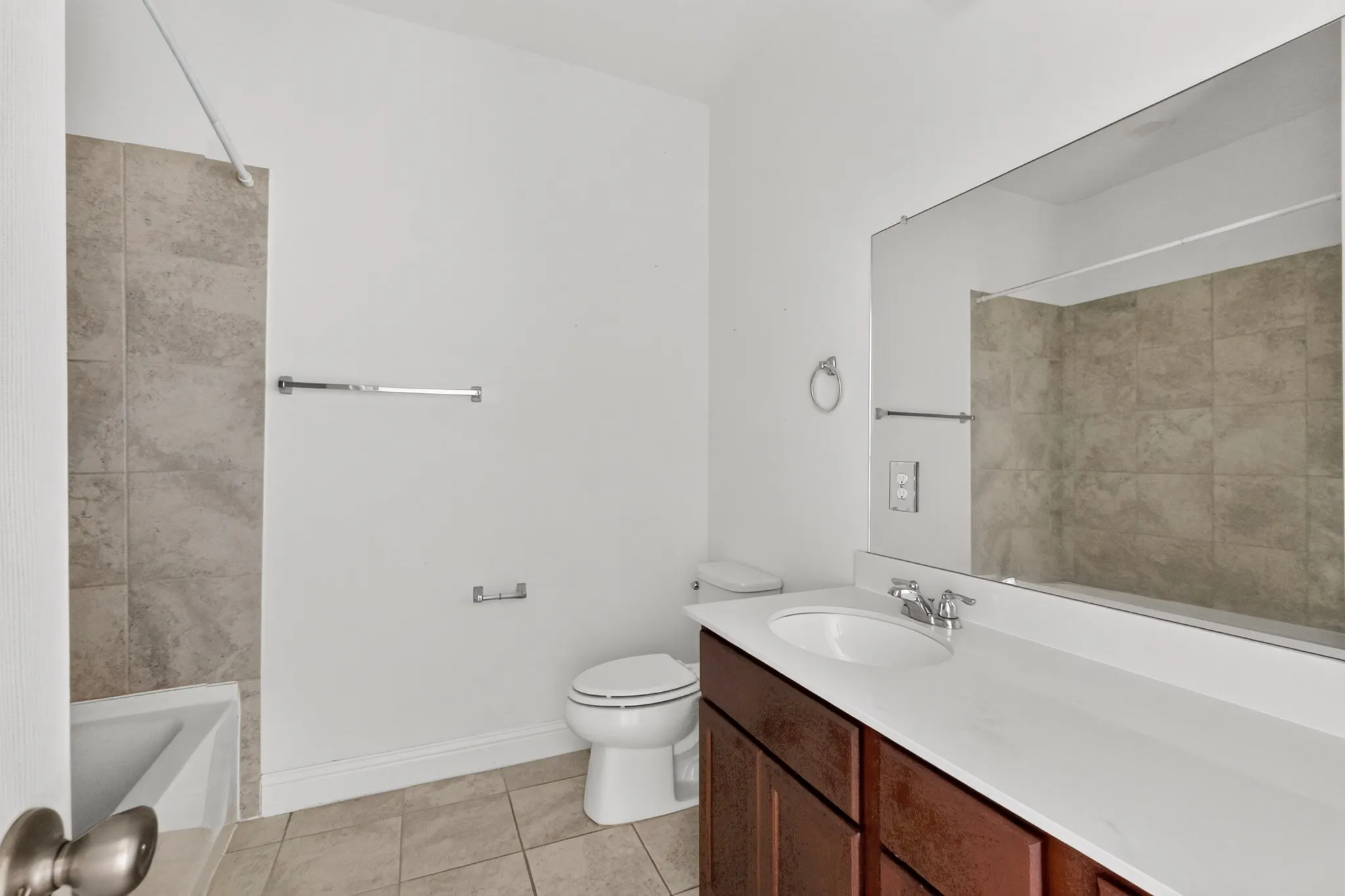 Full vanity with an integrated sink, polished chrome faucet, and expansive mirror