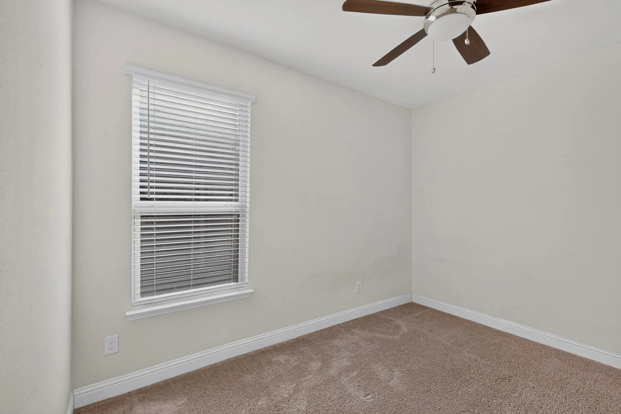 Plush carpeting, window with blinds, and ceiling fan with integrated lighting