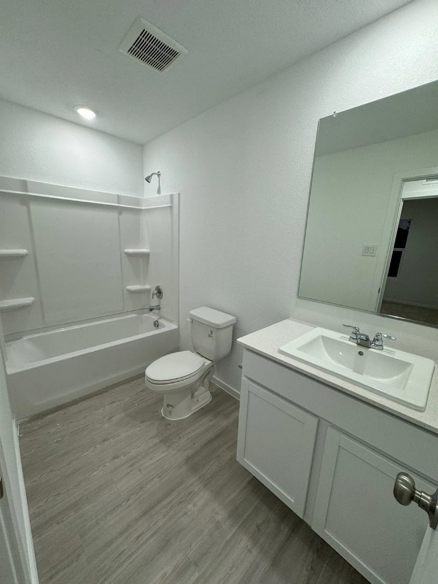 White vanity with integrated sink, chrome faucet, and white countertop