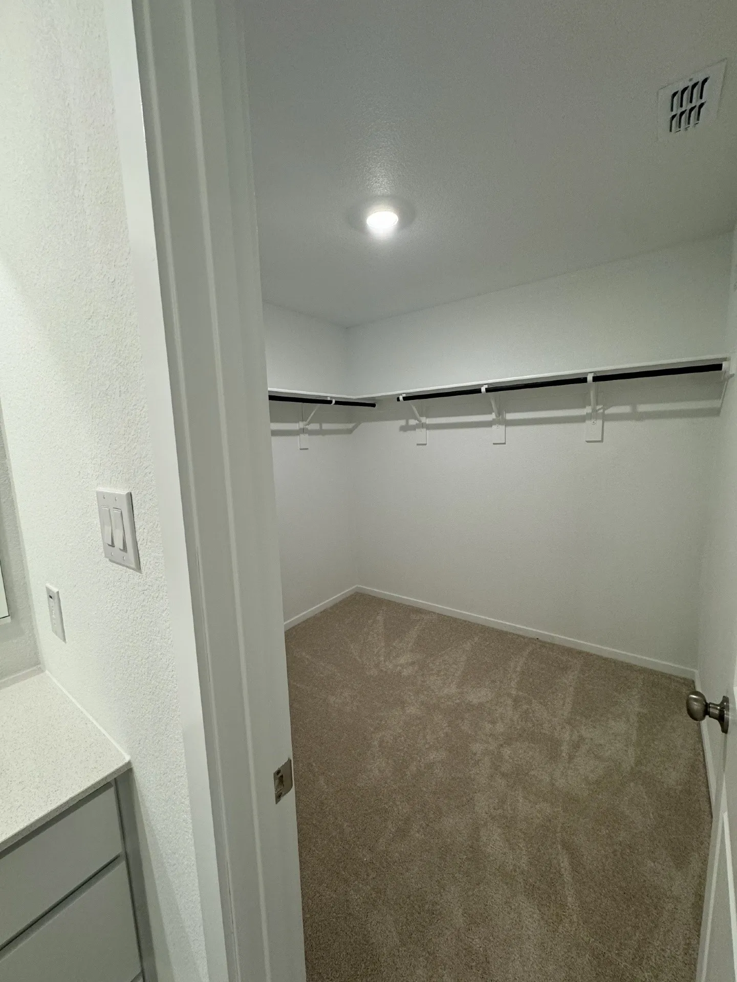 Light wood-finish flooring, white walls, recessed ceiling lighting, and a paneled entry door