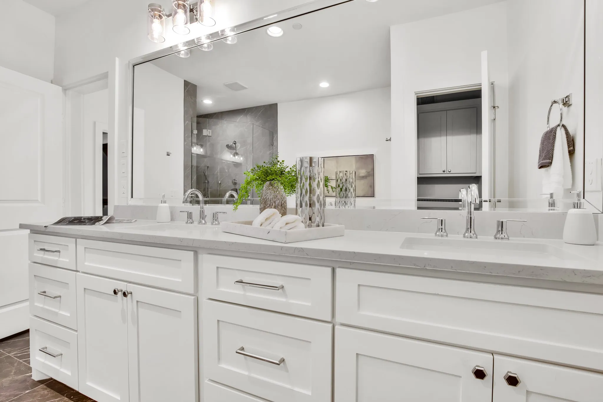 Bathroom with a marble finish shower, double vanity, and recessed lighting