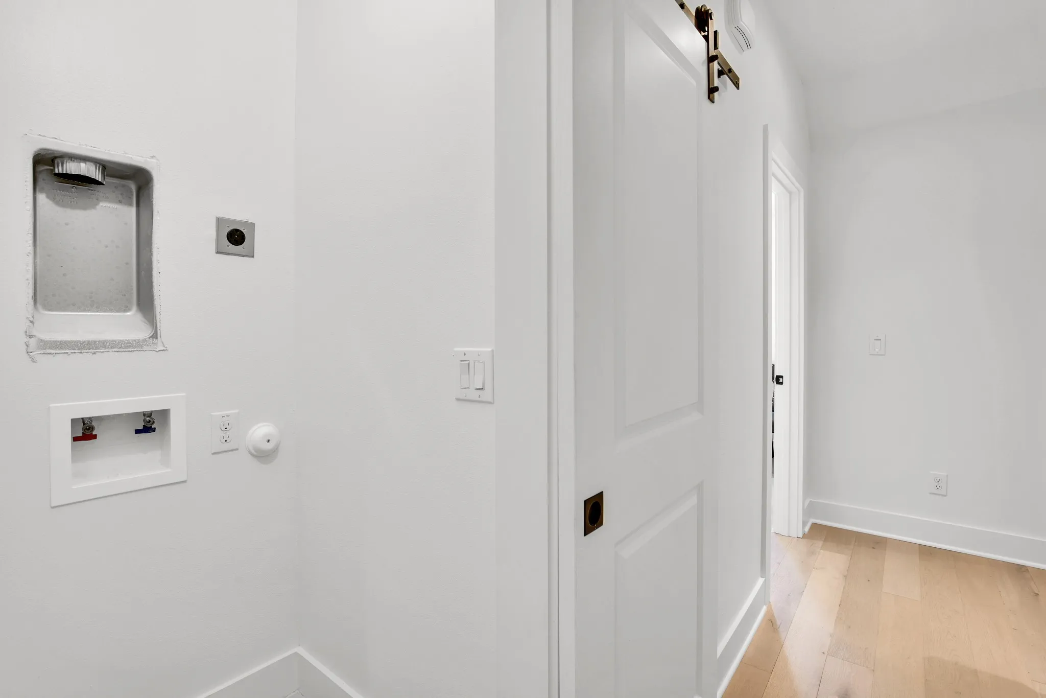 Laundry room featuring electric dryer hookup, light wood finished floors, a barn door, and hookup for a washing machine