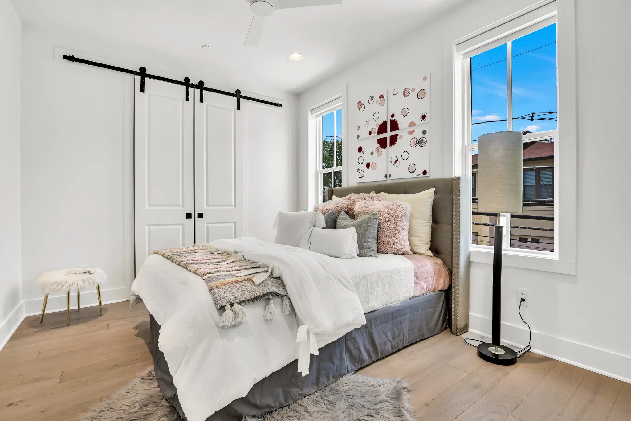Bedroom featuring a barn door, light wood-type flooring, a ceiling fan, and recessed lighting