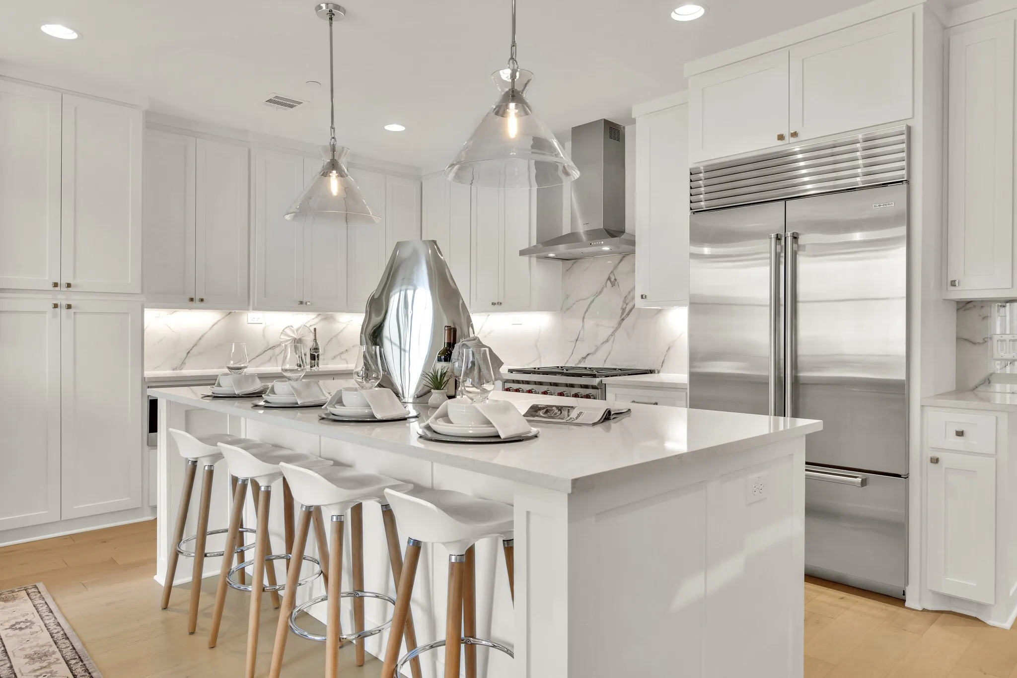 Kitchen featuring appliances with stainless steel finishes, white cabinets, a breakfast bar area, decorative backsplash, and recessed lighting