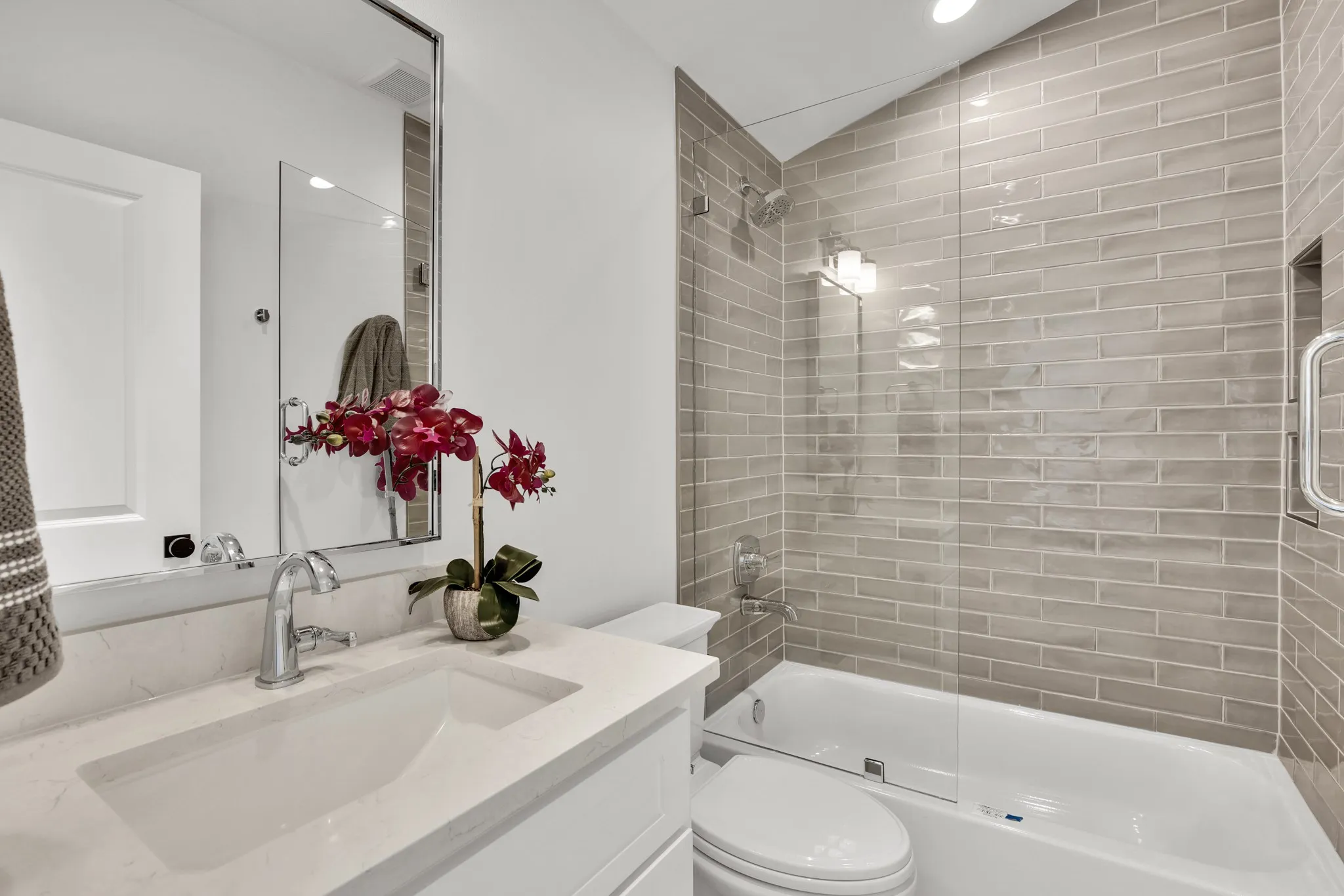 Bathroom with vanity, shower / bath combination with glass door, recessed lighting, and lofted ceiling