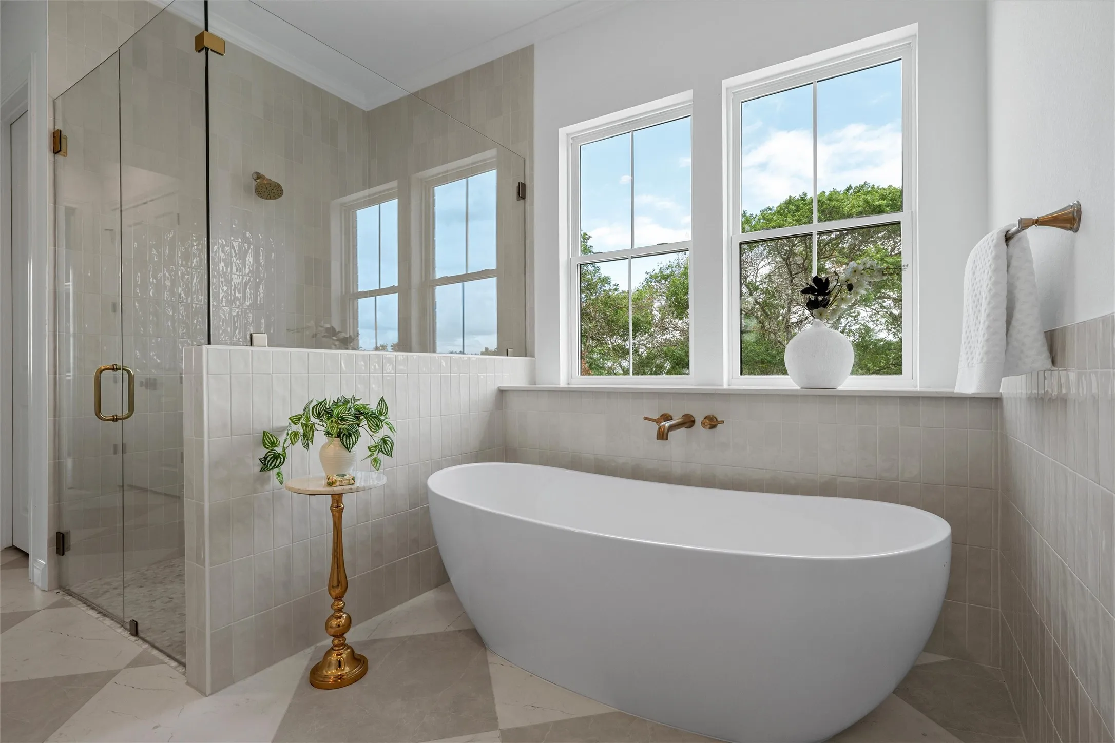 Freestanding soaking tub with wall-mounted fixtures, glass-enclosed shower with a rainfall showerhead, large double-hung windows, and checkerboard tile flooring