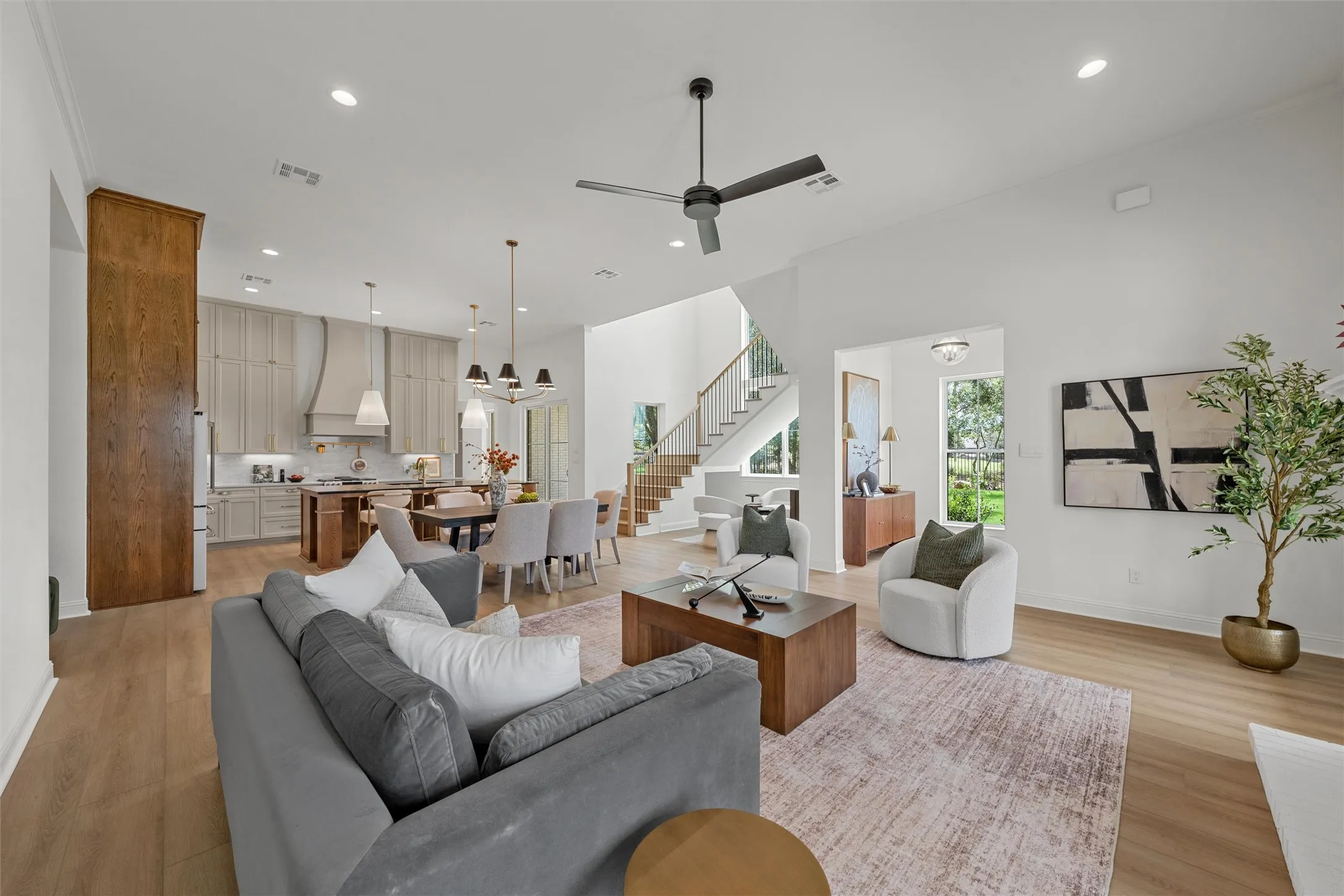 Open-concept living space featuring high ceilings, wood-finish flooring, and recessed lighting