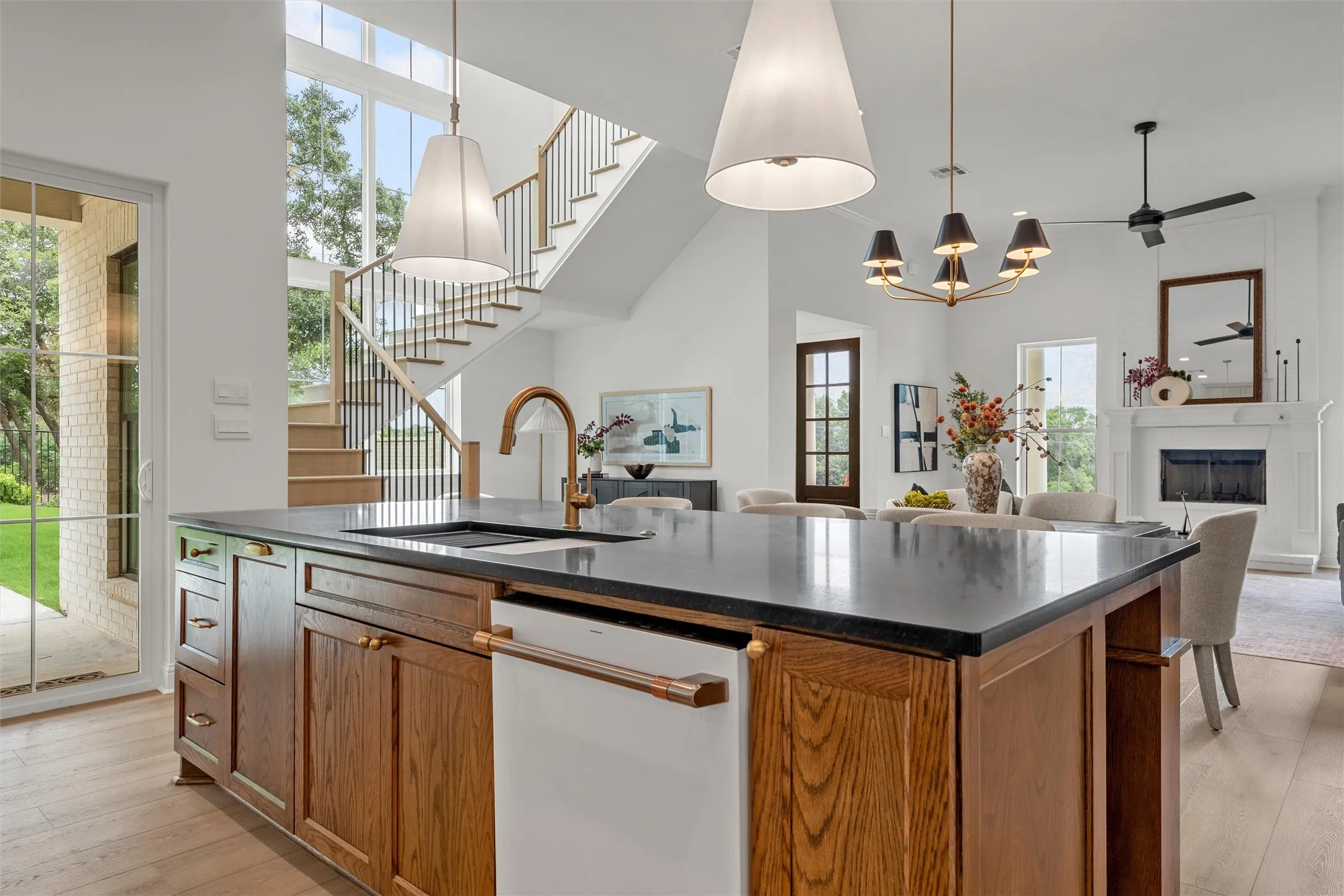 Kitchen island with dark countertop, integrated sink, and bronze-finish faucet