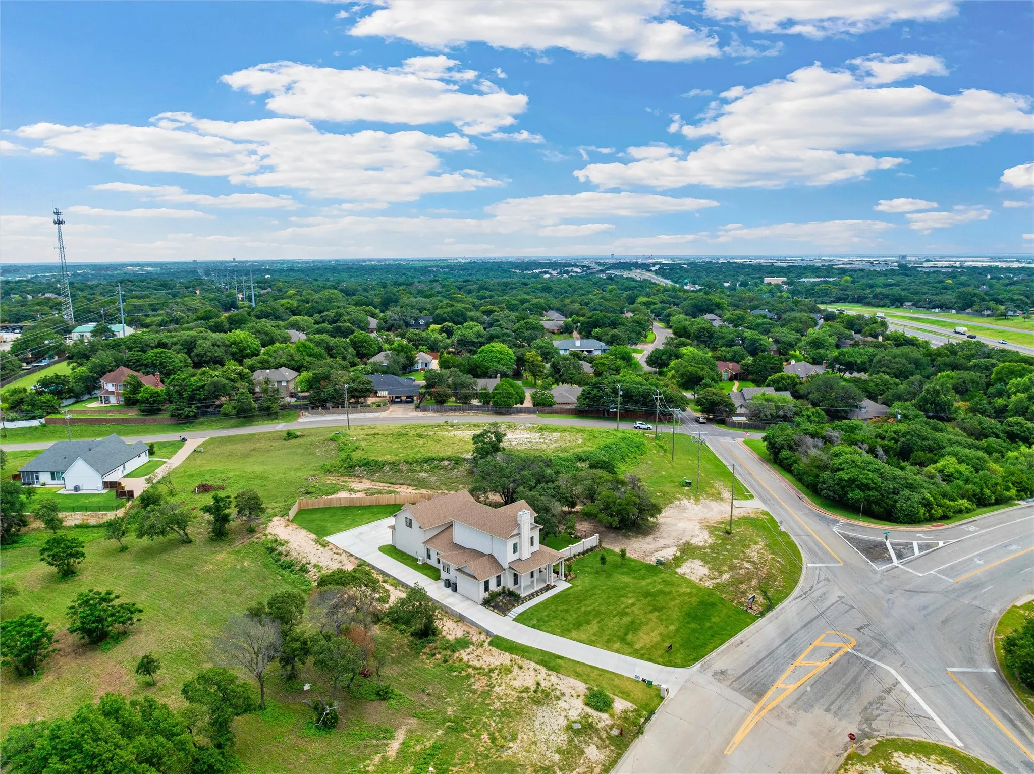 Aerial perspective showcasing the property's expansive lot, mature trees, and proximity to thoroughfares