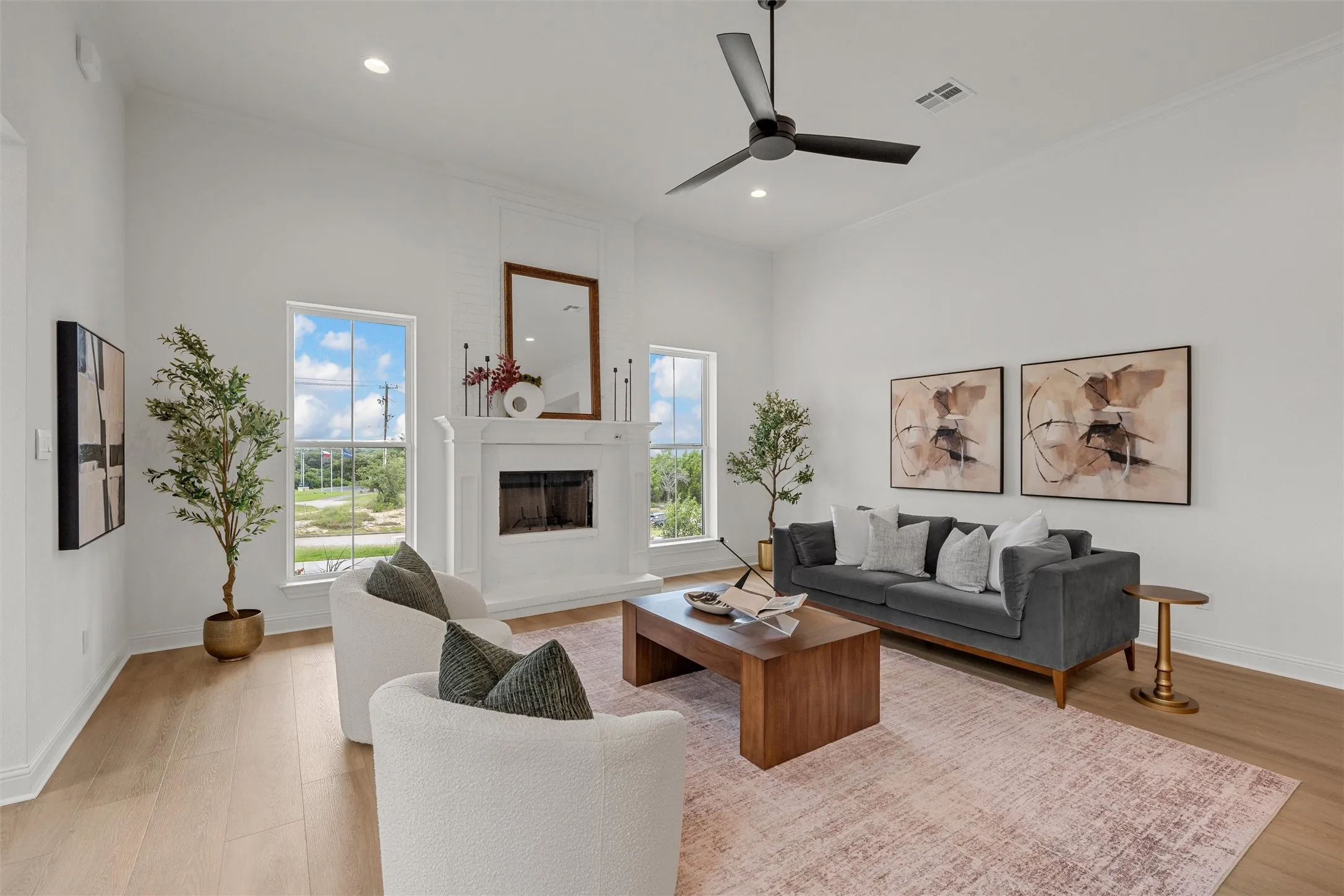 Vaulted ceilings, wood-finish flooring, recessed lighting, a fireplace with a mantel, and a ceiling fan