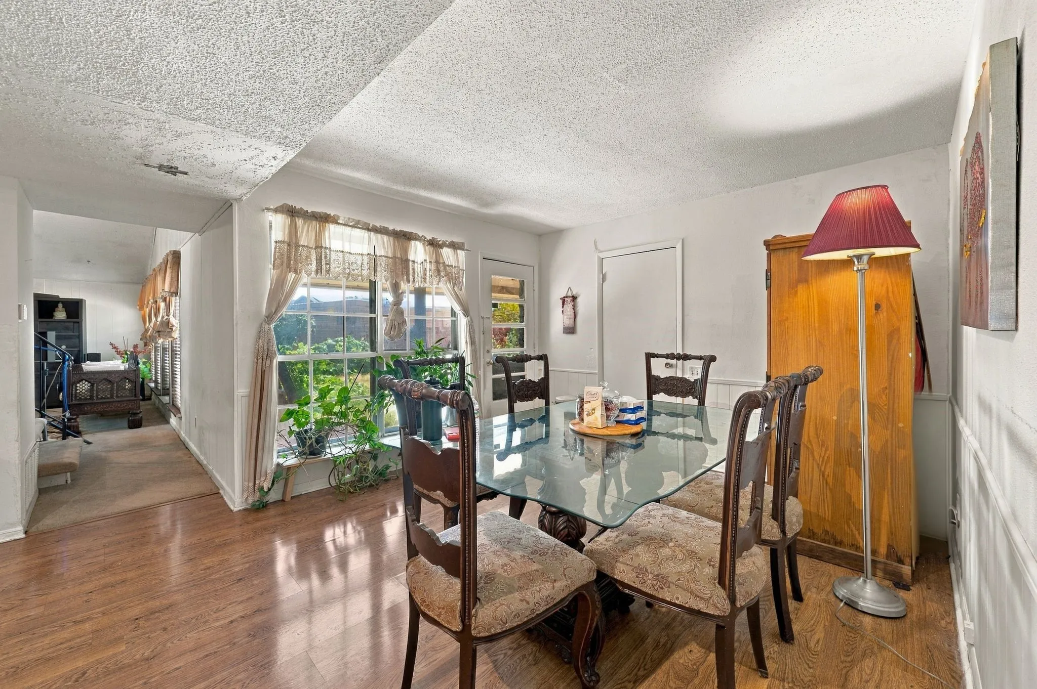Dining room view from the kitchen with lots of natural light, way to the Living room and door to the back patio.