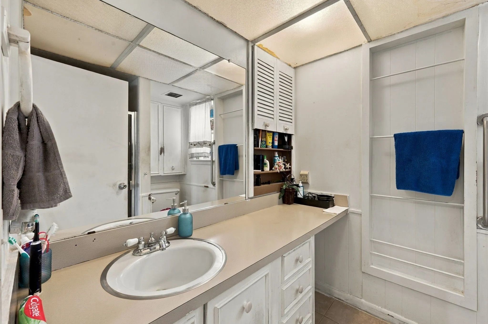 Hallway bathroom with ample counterspace and standing shower