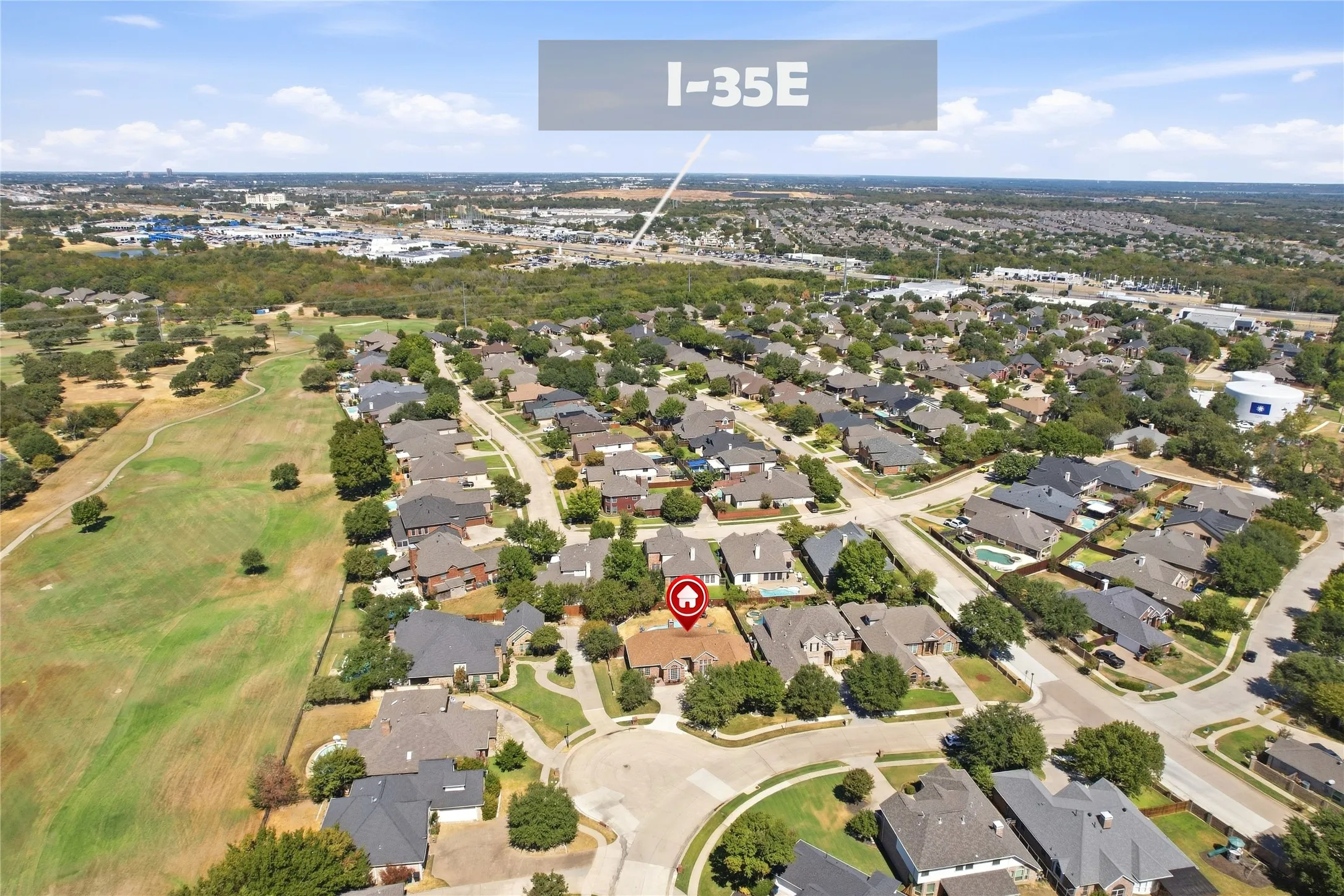 Residential property surrounded by mature trees, situated along a curbed street