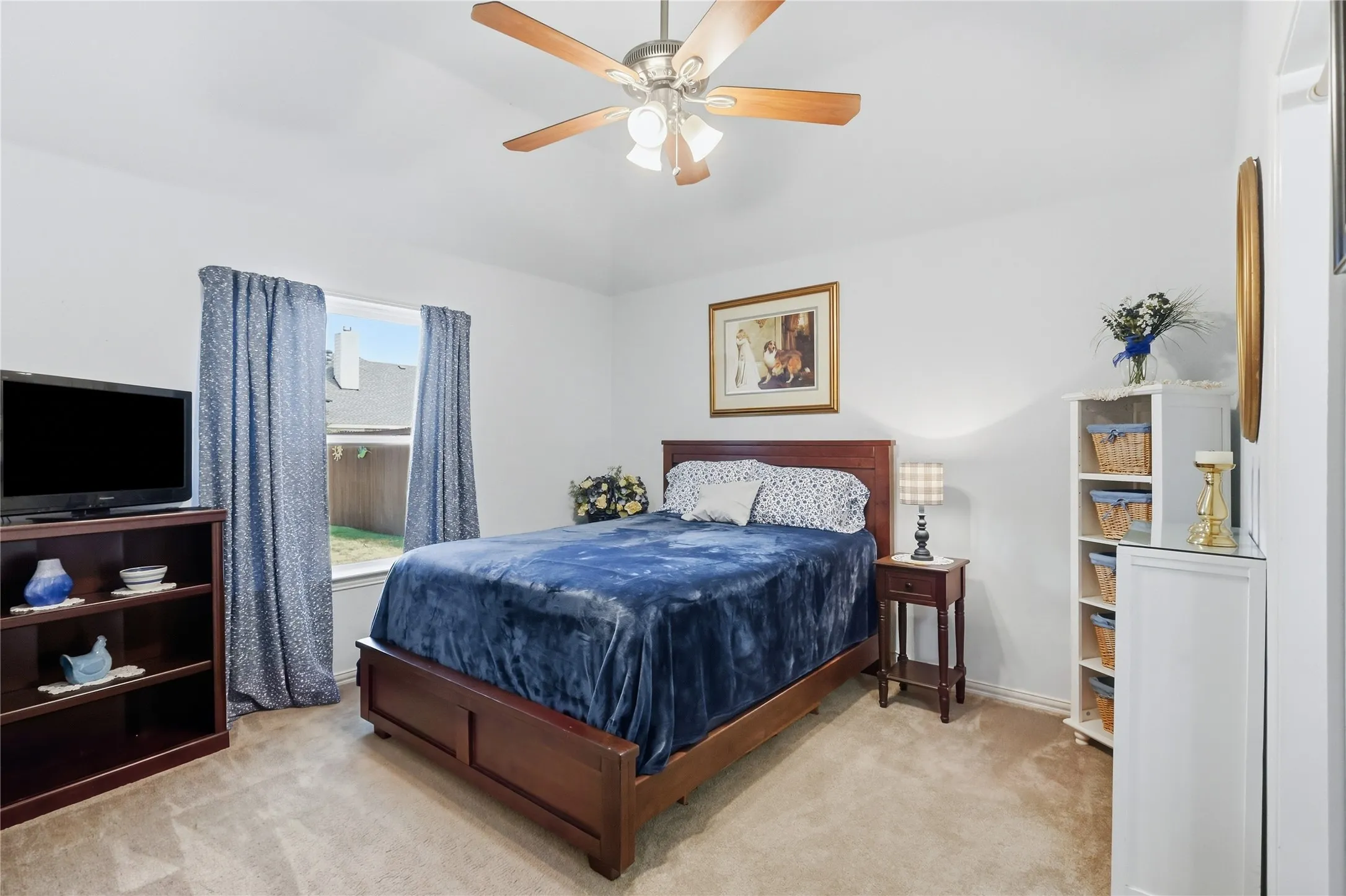 Ceiling fan with light fixture, window with backyard visibility, wall-to-wall carpeting, and white painted walls