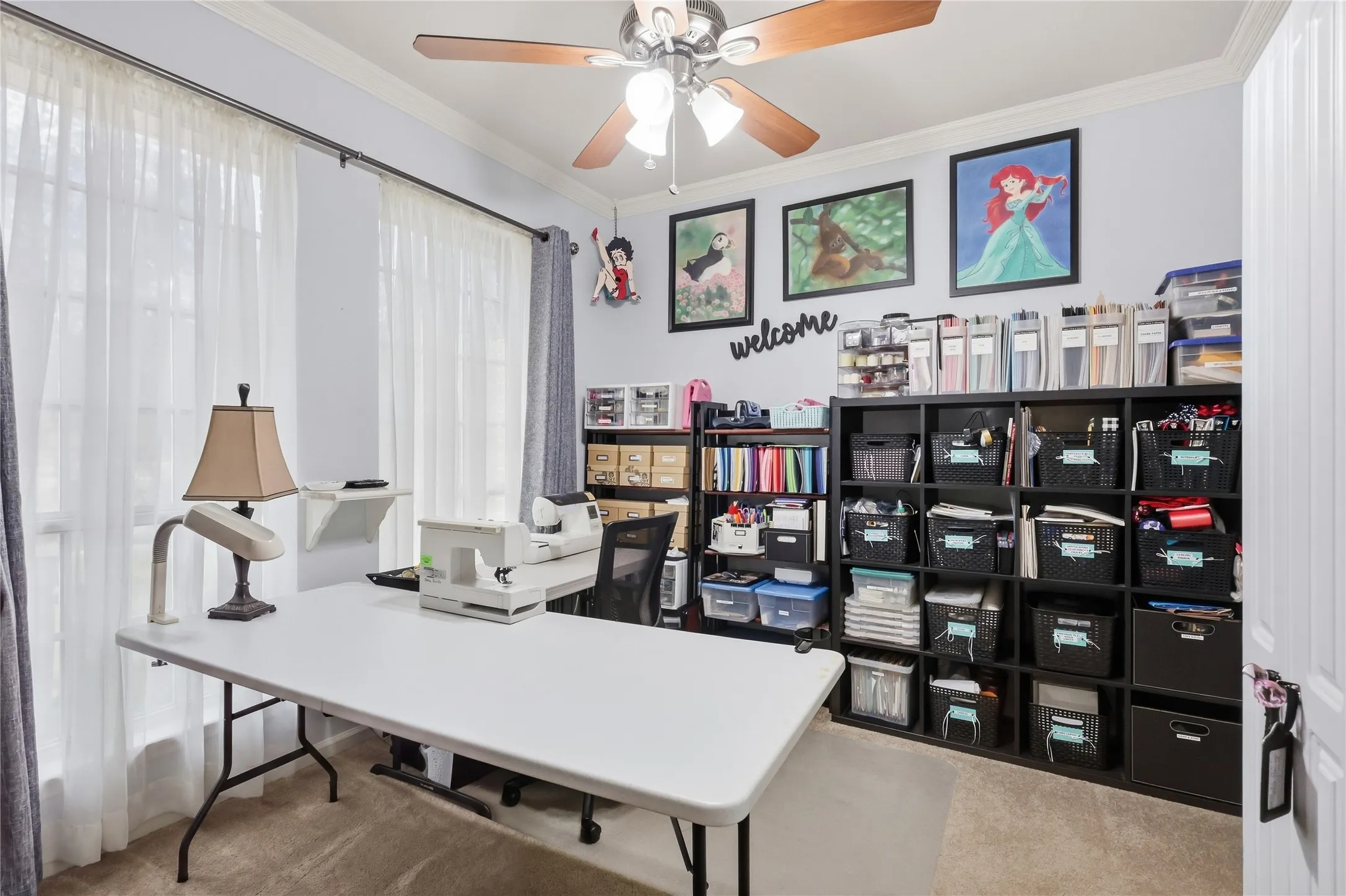Recessed ceiling fan with integrated lighting, multiple windows with sheer drapery, light-colored wall paint, and carpeted flooring