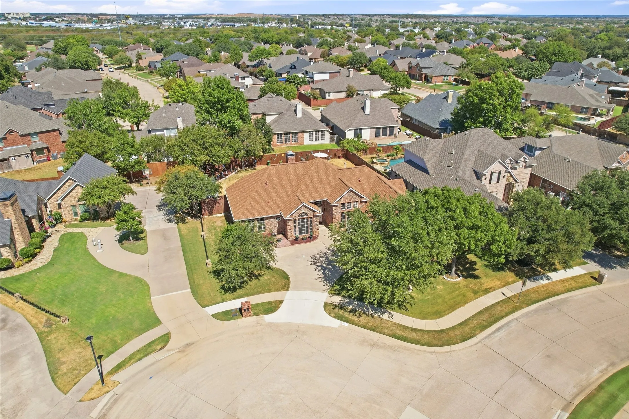 Curb appeal featuring a brick exterior and a paved driveway