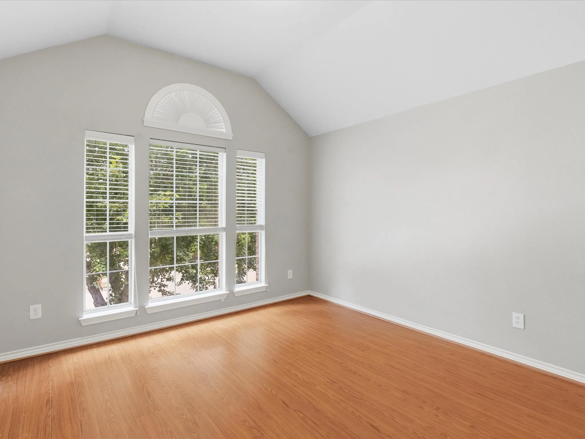 Vaulted ceiling featuring a decorative arch window