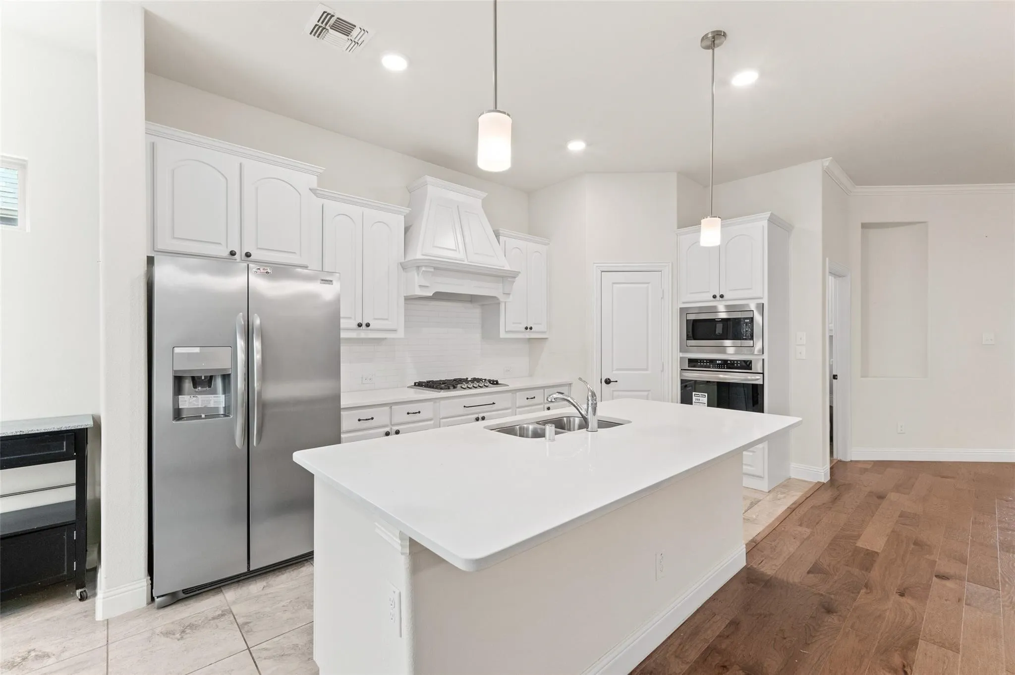Kitchen island with integrated sink, stainless steel dishwasher, and white countertop