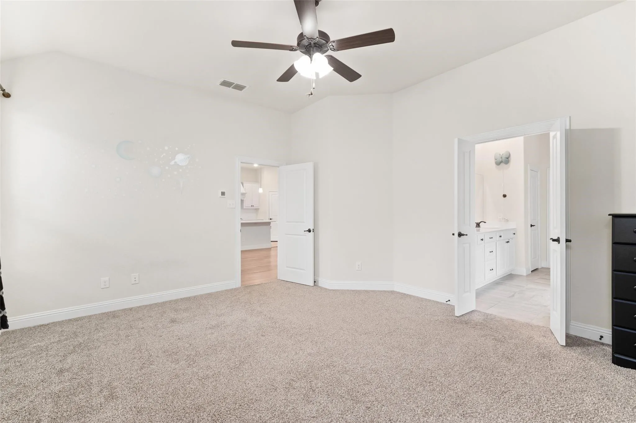 Hardwood flooring, corner fireplace with mantel, ceiling fan, large window, and staircase with wrought iron balusters