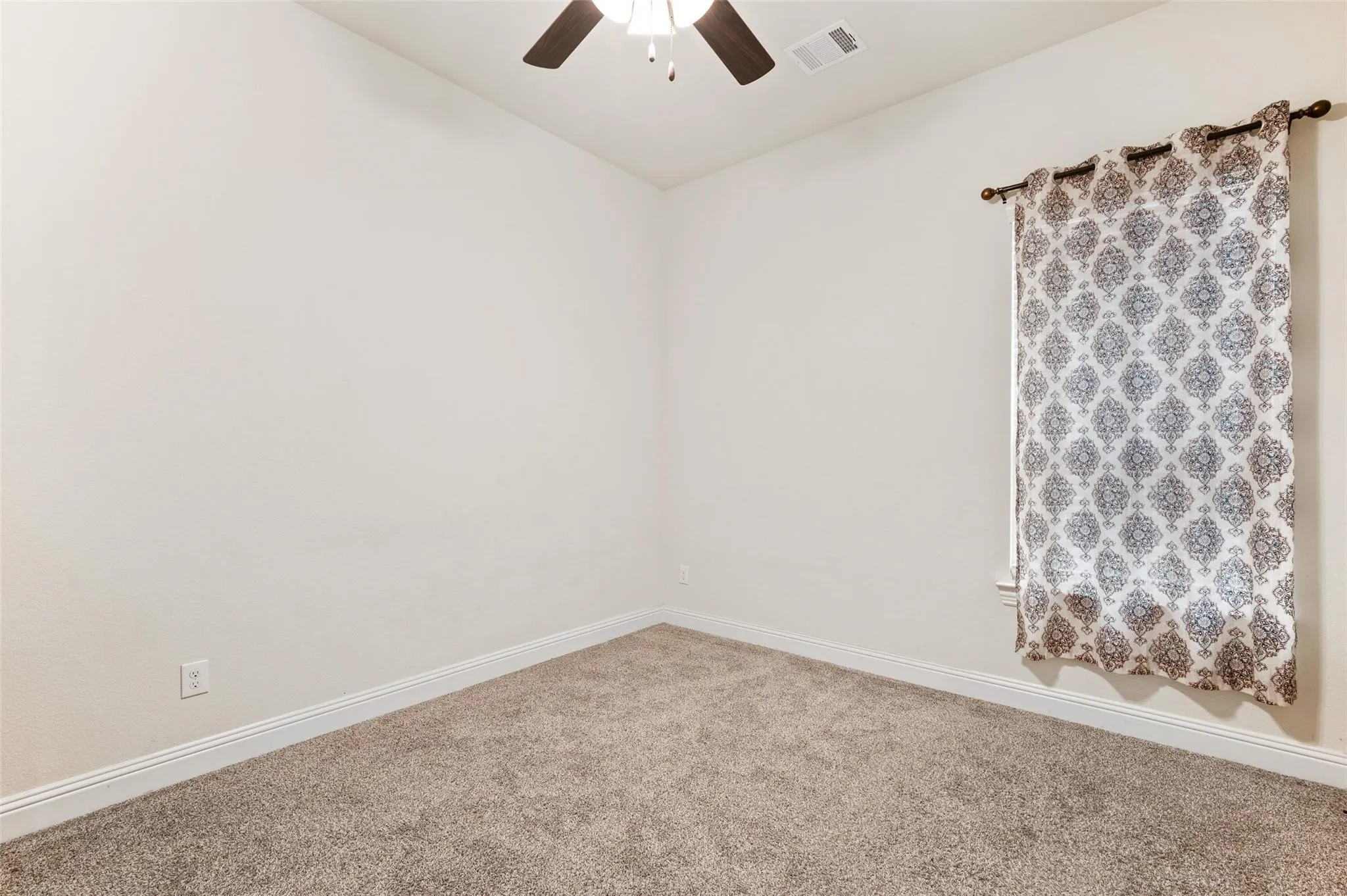 Recessed window with decorative curtain rod, ceiling fan with light fixture, and carpeted flooring
