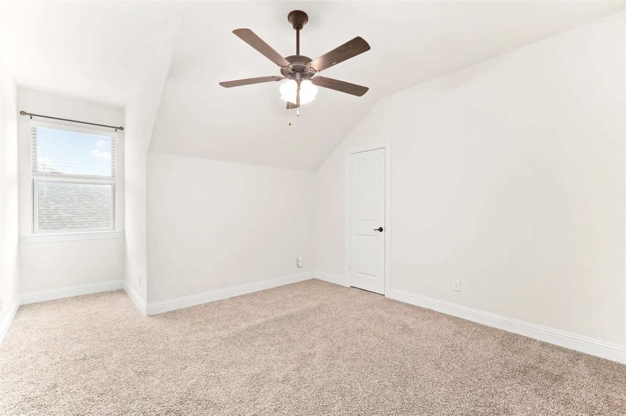 Recessed window with blinds, ceiling fan with integrated lighting, white interior door with dark hardware, and neutral carpeting