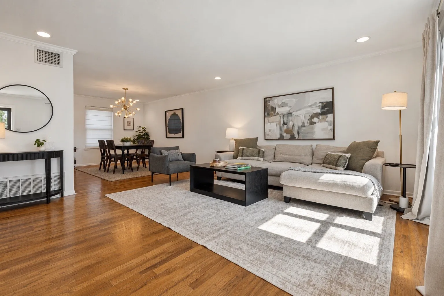 Hardwood flooring throughout, recessed ceiling lighting, crown molding, and a dining area with a contemporary chandelier