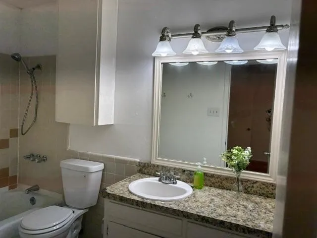 En-suite Bathroom -Vanity with a granite-style countertop, undermount sink, and brushed nickel faucet