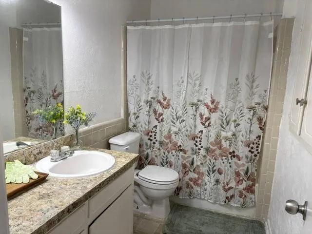 Bathroom Vanity with a basin sink, chrome faucet, and a light-colored countertop