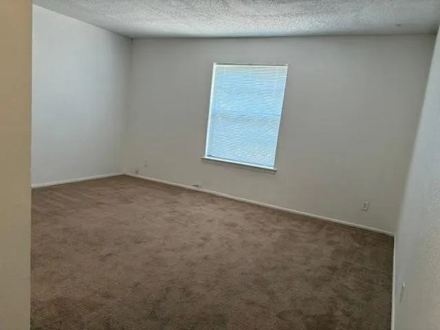 Multiuse room for office/craft/play with Neutral wall finishes with a single window featuring horizontal blinds