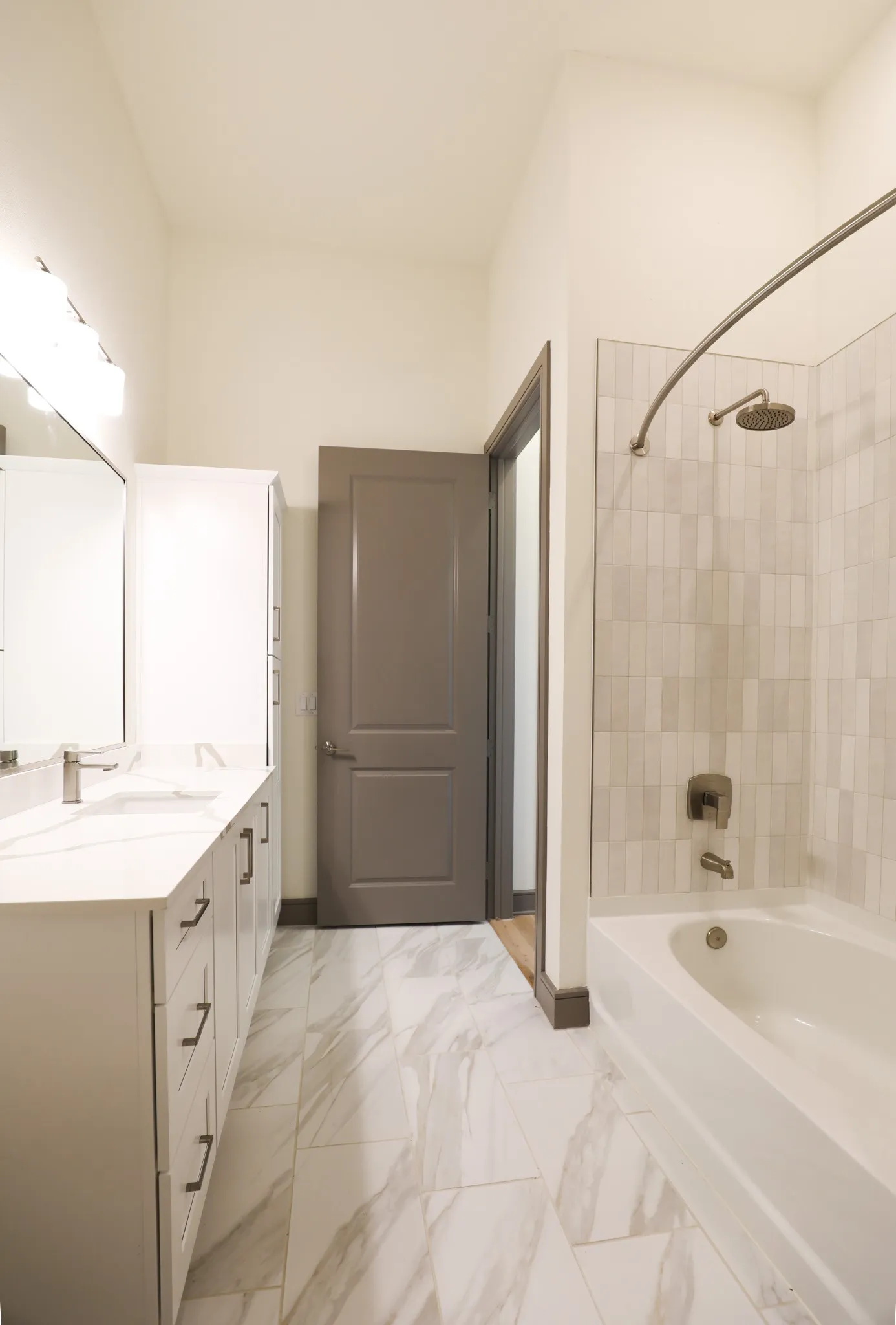 Bathroom featuring a single vanity with stone-finish countertop, undermount sink, and brushed nickel faucet