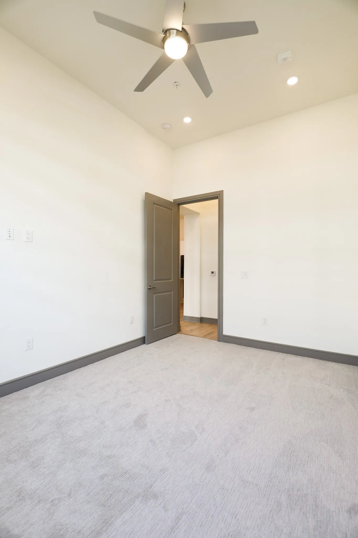 Recessed lighting, ceiling fan, neutral wall tones, gray trim, and gray carpeting