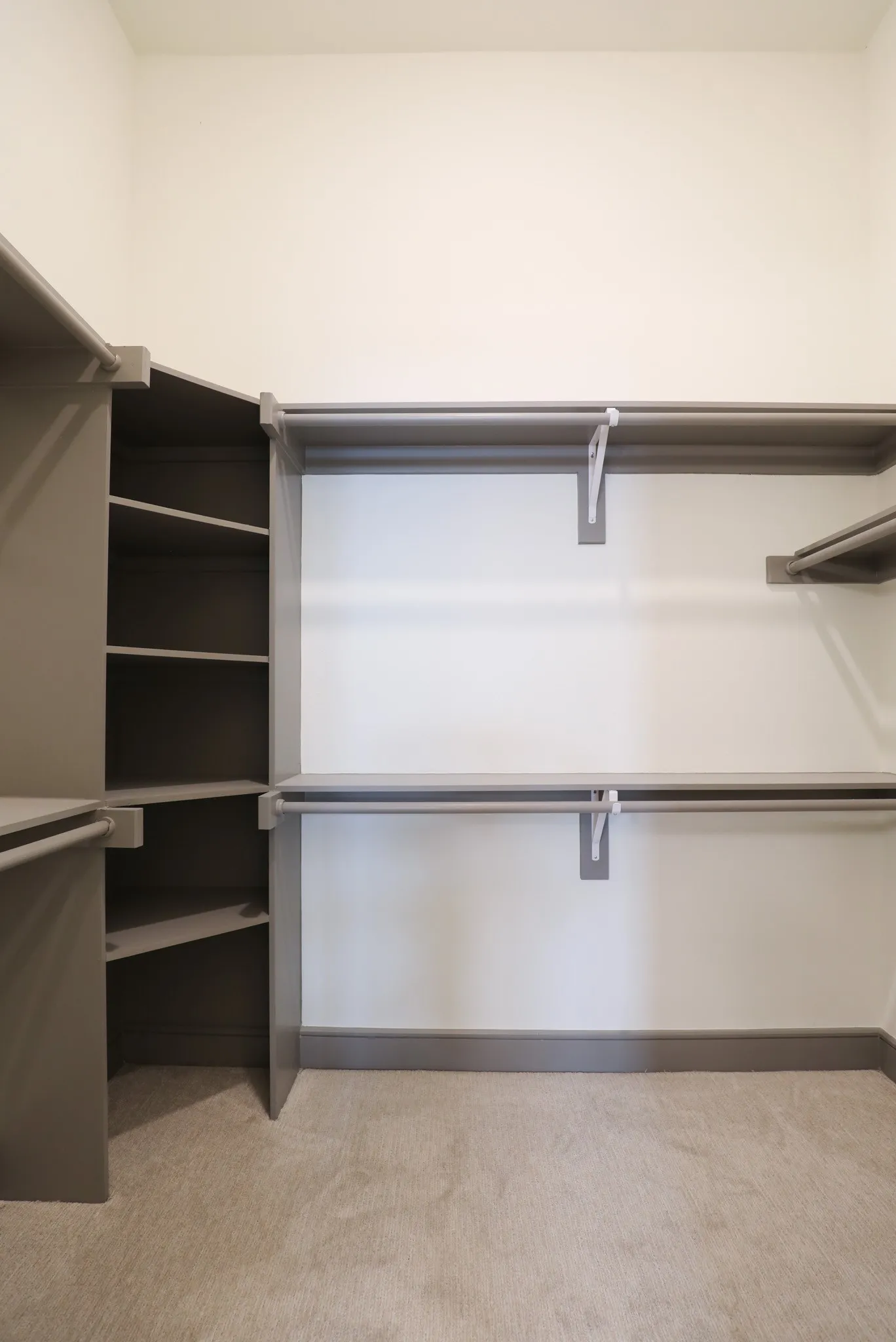 Built-in shelving, multiple hanging rods, and an additional storage shelf