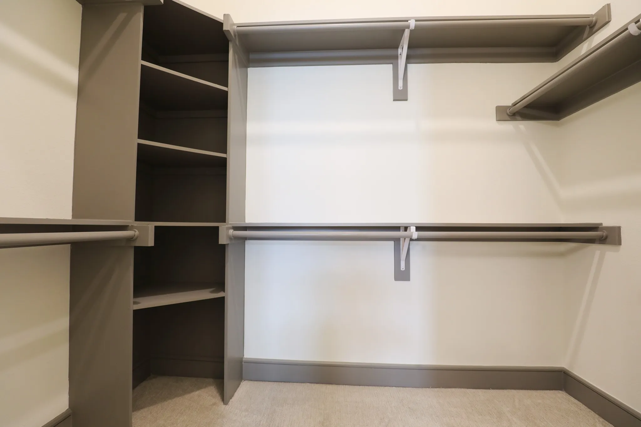 Built-in closet system featuring multiple hanging rods and integrated corner shelving