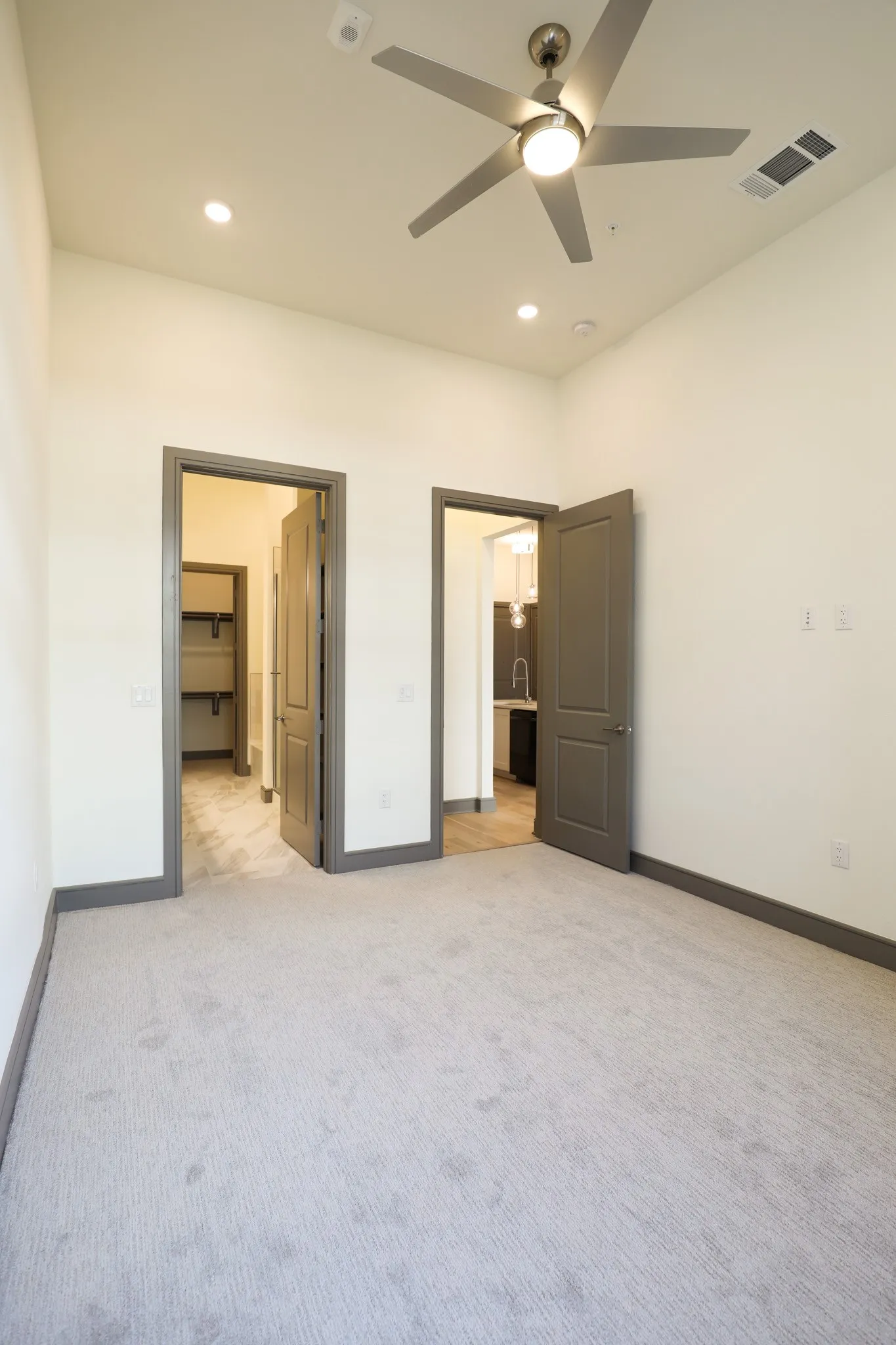 Recessed lighting, ceiling fan with integrated light, light-colored carpeting, dark trim, and dark-paneled doors