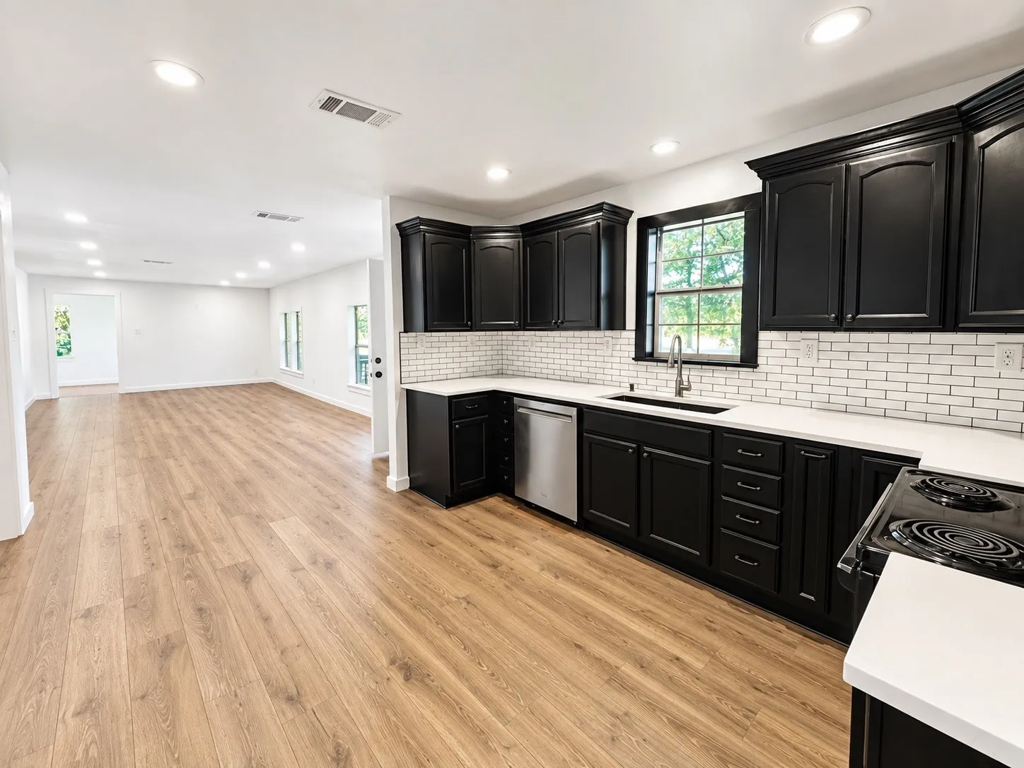Kitchen featuring dark shaker-style cabinetry, white countertops, subway tile backsplash, and stainless steel appliances
