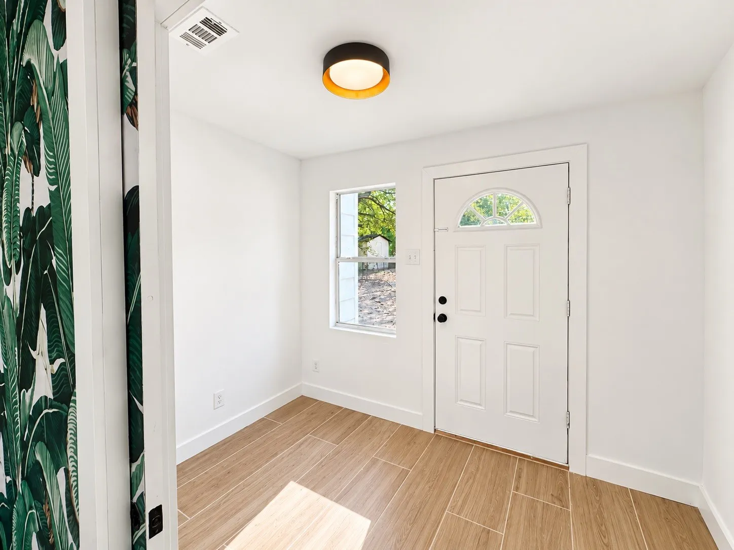 Wood-finish tile flooring, white walls, and a recessed ceiling light